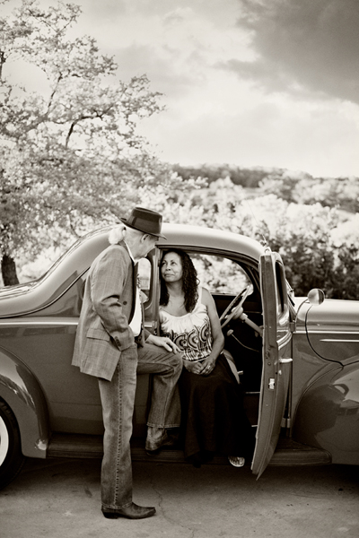 Man in fedora with woman in classic car, black and white